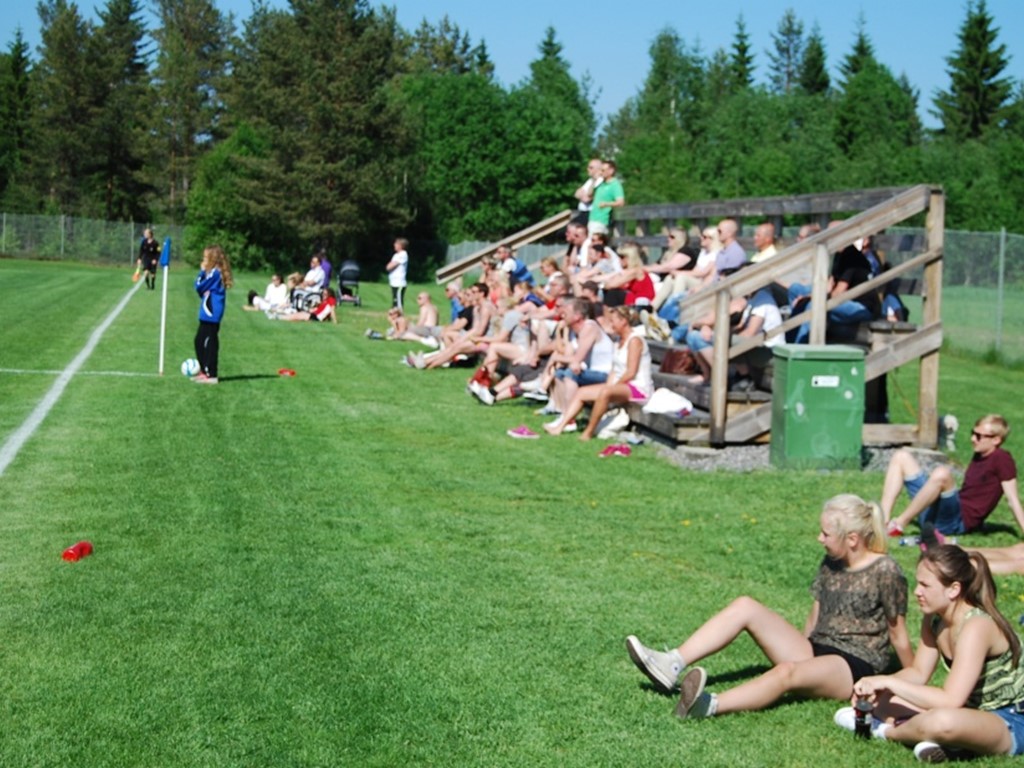 En välfylld läktare i solen när IFK Timrås damer tog emot Bik SK i en match i division 1 Norrland 2013. Foto: Janne Pehrsson, Lokalfotbollen.nu.