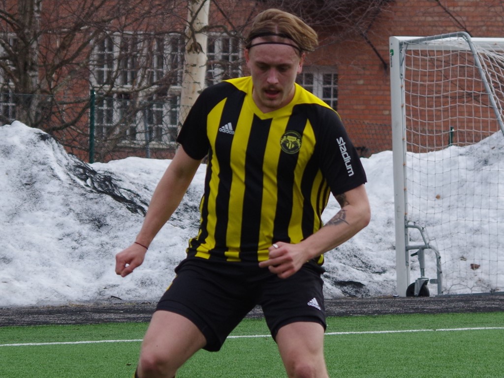 Fredrik Thelander med snödrivorna i bakgrunden. Foto: Pia Skogman, Lokalfotbollen.nu.